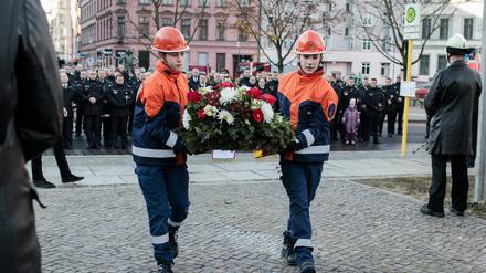 26.11.2023, Berlin: Mitglieder der Berliner Jungend-Feuerwehr tragen einen Gedenk-Kranz vor den Gedenkstein während einer Andacht zum Totensonntag am Feuerwehr-Ehrenmal ihrer Verstorbenen. Foto: Carsten Koall/dpa +++ dpa-Bildfunk +++