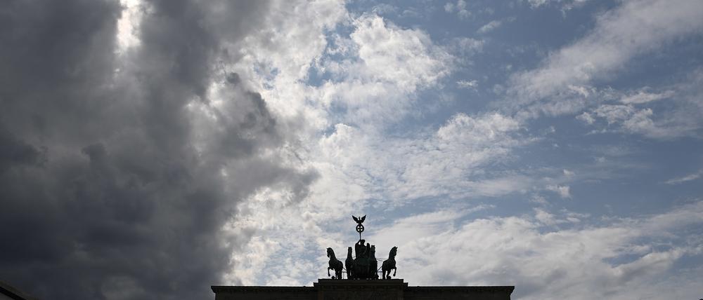 Ein graues Wolkenband zieht hinter der Silhouette der Quadriga auf dem Brandenburger Tor auf.