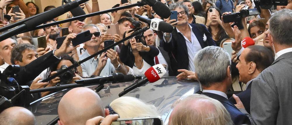 Berlusconi in einer Lieblingsrolle: In dieser Woche begleitete ein Schwarm von Medienleuten und Kameras jeden Auftritt des Ex-Premiers (im Bild rechts im Profil)