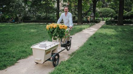 Die Urne sichtbar platziert, das Lastenrad mit Blumen geschmückt: Bestatter Eric Wrede mit seinem Lastenrad in Berlin.