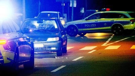 Ein beschädigtes Fahrzeug und Polizeiwagen stehen in Homburg an einem Zebrastreifen.