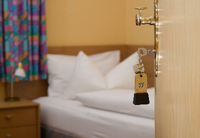 Ein Zimmermädchen macht in einem Hotel ein Bett.