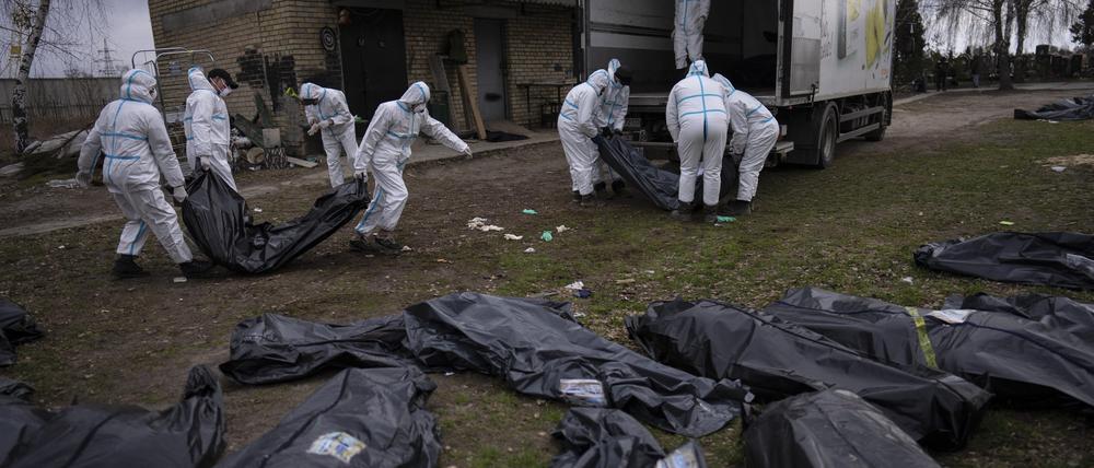 Freiwillige laden Leichen von in Butscha, einem Außenbezirk von Kiew, getöteten Zivilisten auf einen Lastwagen.