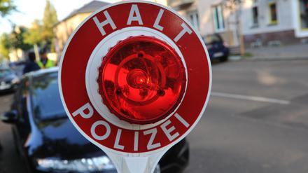 Ein Polizist stoppt in Berlin an der Seeburger Straße mit einer Kelle ein Auto. (Symbolbild)