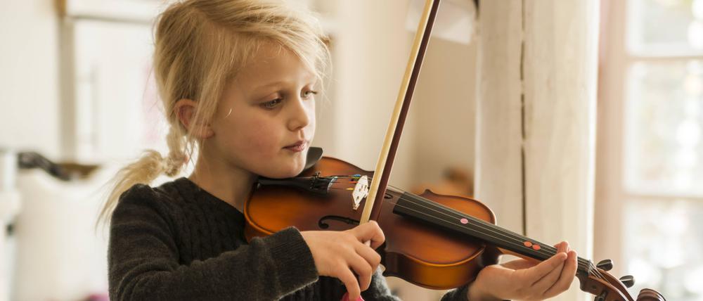 Ein kleines Mädchen spielt Geige.