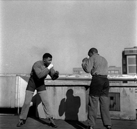 Bob Gosani: Hochverratsprozess, Ende Runde eins. Mandela boxt auf dem Dach eines Zeitungshauses in Johannesburg.