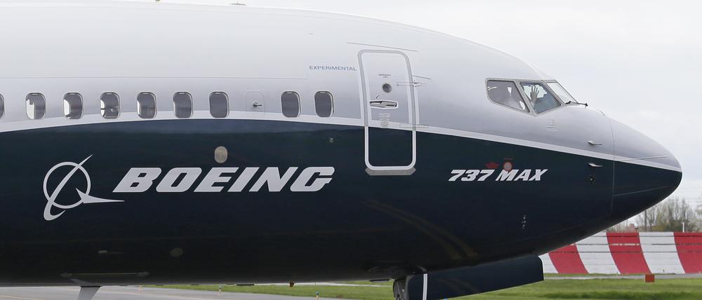 Ein Pilot winkt aus der Pilotenkabine eines Flugzeuges vom Typ Boeing 737 MAX 9 auf dem Flughafen. 