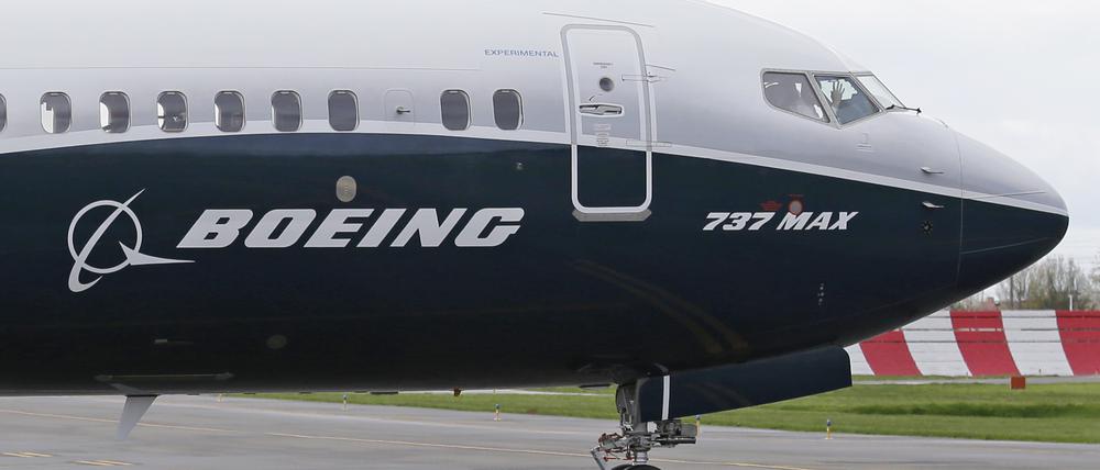 Ein Pilot winkt aus der Pilotenkabine eines Flugzeuges vom Typ Boeing 737 MAX 9 auf dem Flughafen. 