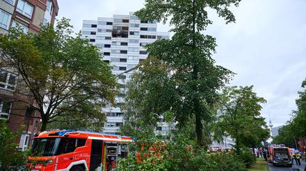 Fahrzeuge der Feuerwehr stehen vor einem Hochhaus, in dem ein Feuer ausgebrochen war. Wegen eines Brandes im zwölften Stock eines Hochhauses in Berlin sind zwei Menschen aus dem Gebäude gesprungen und ums Leben gekommen.