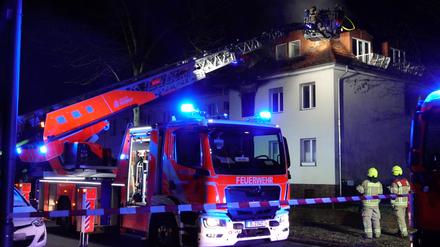 Einsatzkräfte der Feuerwehr löschen den Brand in einem Haus. In einem Haus in Berlin-Nikolassee ist am Samstagabend ein Feuer ausgebrochen.