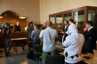 Vier Angeklagte (links der Tischreihe) stehen in einem Gerichtssaal im Amtsgericht Tiergarten.