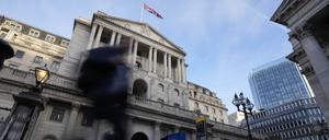 Menschen gehen an der Bank of England in London vorbei. Die britische Notenbank setzt ihren Kampf gegen die hohe Inflation fort. Dazu hob sie ihren Leitzins erneut deutlich an.