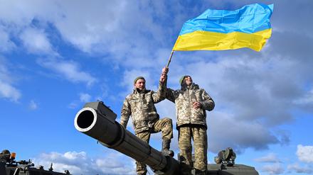 Ukrainische Soldaten mit ihrer Nationalflagge bei einem Panzer-Training in Großbritannien.