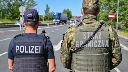 Ein deutscher Polizist und sein polnischer Kollegen stehen am Autobahngrenzübergang am Gemeinsamen Zentrum der Deutsch-Polnischen Polizei- und Zollzusammenarbeit. g