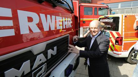 Bundeskanzler Olaf Scholz (SPD) unterschreibt auf einem Feuerwehrauto, das für die Ukraine gespendet wird.