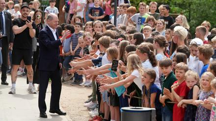 Bundeskanzler Olaf Scholz (SPD) besucht anlässlich des EU-Projekttages die Eigenherd-Grundschule in Kleinmachnow und begrüßt die Kinder auf dem Schulhof.