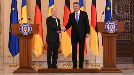 Bundeskanzler Olaf Scholz (l, SPD) und Klaus Iohannis (PNL), Präsident von Rumänien, reichen sich im Cotroceni-Palast während des Antrittsbesuchs des deutschen Politikers nach einer Pressekonferenz die Hand.