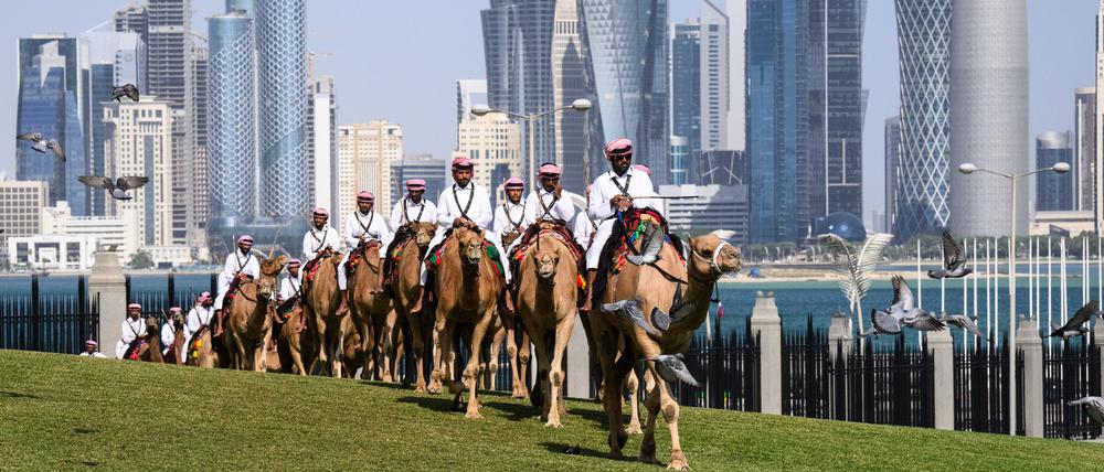 Die Ehrengarde des Emir von Katar reitet auf Kamelen um den Palast des Emirs, als die Delegation des Bundespräsidenten am Palast eintrifft. 