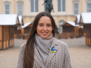 Iryna Bushmina aus Kiew assistiert dem Veranstalter des Berliner Weihnachtsmarkts vor dem Schloss Charlottenburg.