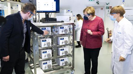 Knauer-Geschäftsführer Carsten Losch und Kate Monks, Leiterin Applikationen, Akademie & Qualität erläutern Angela Merkel ein IJM-Skid zur Lipid-Nanopartikelherstellung für mRNA-Impfstoffe.