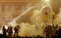 Katalanische Demonstranten werfen einen Tränengas-Behälter zurück auf die Polizei.