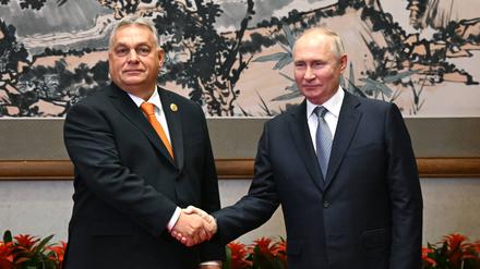 Der ungarische Ministerpräsident Viktor Orbán und der russische Präsident Wladimir Putin schütteln die Hand vor ihrem Treffen in Peking. 