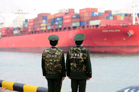 Qingdao: Polizisten beobachten die Ankunft eines Containerschiffs.