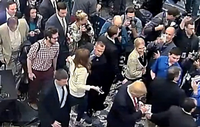 Rechts unten ist Donald Trump zu sehen, in der Mitte Corey Lewandowski, der Michelle Fields (in heller Kluft) am Arm fasst und abdrängt.