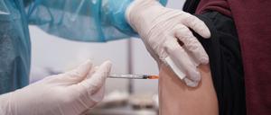 Ein junger Mann wird mit einer Booster-Dosis eines Corona-Impfstoffs geimpft (Symbolfoto).