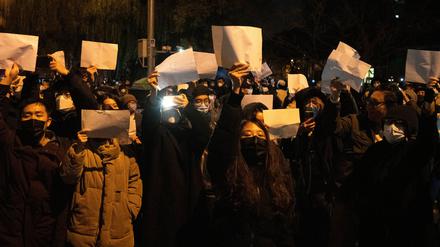 Demonstrierende in der chinesischen Hauptstadt Peking halten leere Papiere hoch.