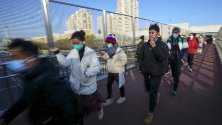 Maskierte Pendler in Peking auf einer Fußgängerbrücke am 8. Dezember