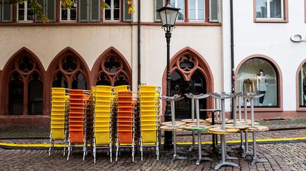Gestapelte Tische und Stühle eines Eiscafés in Freiburg.