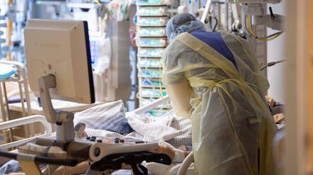 Ein Intensivpfleger steht auf der Intensivstation eines Krankenhauses neben einem Covid-19-Patienten. (Bild aus 2021)