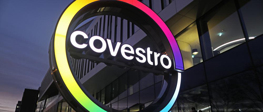 Das Logo des Kunststoffkonzerns Covestro leuchtet am Morgen vor der neuen Unternehmenszentrale am Chempark Leverkusen.