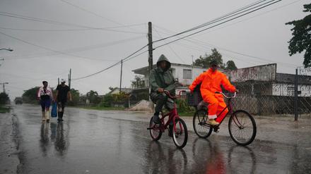 Menschen in Kuba im Regen vor der Ankunft des Hurrikans Ian in Coloma. 