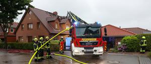 22.05.2024, Schleswig-Holstein, Hamberge: Einsatzkräfte sind mit Nachlöscharbeiten an einem Wohnhaus im Kreis Stormarn beschäftigt, das nach Angaben der Feuerwehr bei Unwetter durch einen Blitzschlag in Brand geraten war. 