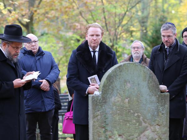 Star-Geiger Daniel Hope (M.) beim Pogrom-Gedenken auf dem jüdischen Friedhof in Potsdam.