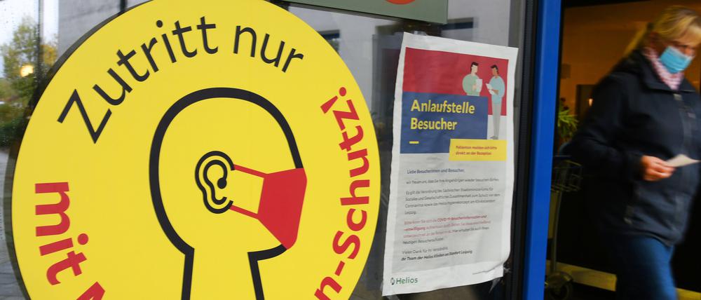 Ein großes Schild mit der Aufschrift «Zutritt nur mit Mund-Nasen-Schutz!» weist neben einem Eingang zu einer Klinik in Leipzig auf die Maskenpflicht hin. 