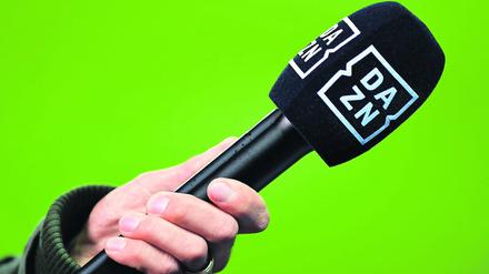 Ein Mikrofon des Kanals DAZN wird vor einen Greenscreen gehalten. (Symbolbild)