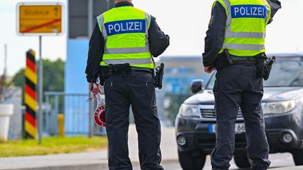 Beamte der Bundespolizei stehen am deutsch-polnischen Grenzübergang Stadtbrücke in Frankfurt (Oder) und kontrollieren Einreisende. 