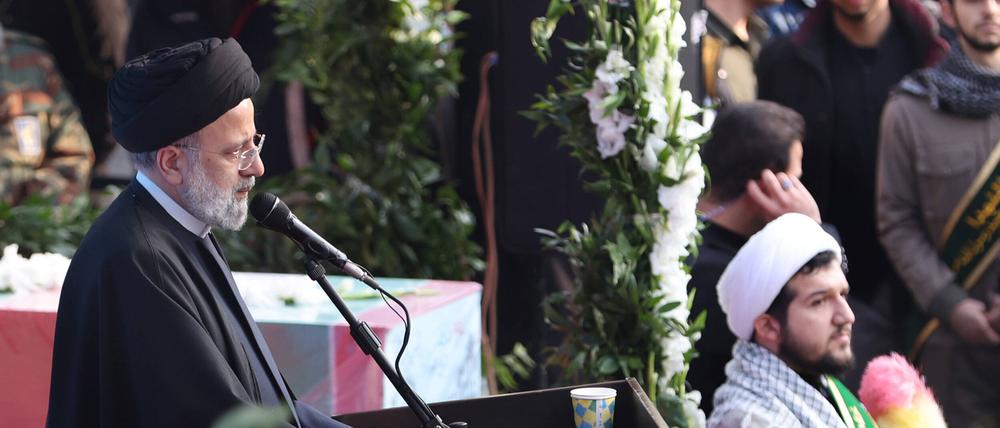Der iranische Präsident Ebrahim Raisi spricht auf einer Beerdigung. 
