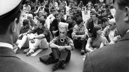 Demonstranten im Sitzstreik werden am 02.06.1967 vor dem Rathaus Schöneberg in Berlin von der Polizei beobachtet. Die Demonstranten protestierten gegen den Besuch des persischen Herrschers Schah Reza Pahlevi. 
