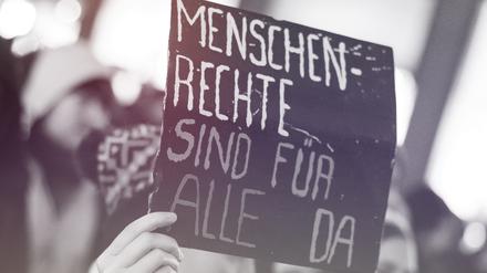 Eine Frau hält am 15.10.2015 in der Innenstadt in Hamburg während einer Demonstration gegen die Verschärfung des Asylrechts ein Schild mit der Aufschrift „Menschenrechte sind für alle da“. Zuvor hatte der Bundestag ein Paket mit umstrittenen Änderungen im Asylrecht beschlossen.