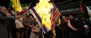 Iranische Demonstranten verbrennen US-amerikanische und israelische Fahnen, um die Tötung von Mitgliedern der iranischen Revolutionswächter (IRGC) zu verurteilen. 
