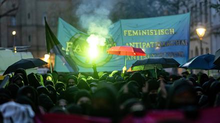 Teilnehmerinnen der linken Demonstration „Take back the night“ in Berlin-Kreuzberg verwenden Regenschirme als Sichtschutz.