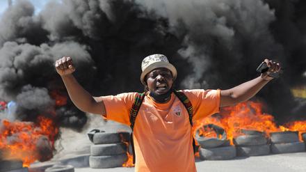 Ein Demonstrant vor einer brennenden Barrikade in Port-au-Prince.