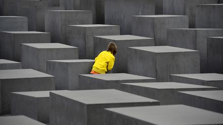 Ein Kind spielt Verstecken am Denkmal für die ermordeten Juden Europas in Berlin-Mitte.