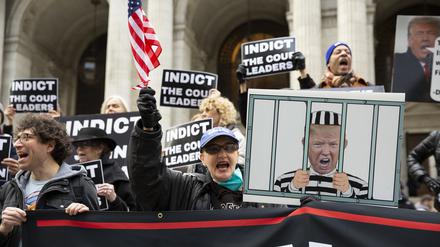 Demonstranten in New York halten Schilder mit einem Bild von Donald Trump im Gefängnis und Schildern mit der Aufschrift „Anklage der Putschisten“ hoch.