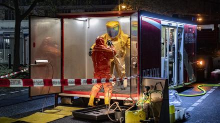 Ein Feuerwehrmann in einem Schutzanzug wird nach einem Einsatz entkontaminiert. Ausgelaufenes Desinfektionsmittel hat am Freitagabend einen Feuerwehreinsatz bei einem Kosmetikhersteller in Berlin-Charlottenburg ausgelöst. 