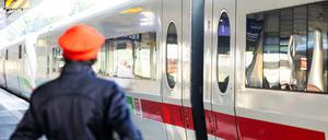 Ein Mitarbeiter der Deutschen Bahn (DB) steht neben einem ICE-Zug an einem Gleis im Hauptbahnhof Hannover.